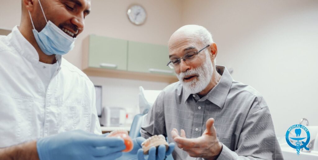 Na obraze je zobrazený zubár v lekárskom plášti a starší muž so sivou bradou v košeli a saku počas návštevy zubára. Zubár sa usmieva a pacient gestikuluje rukami, čo naznačuje prebiehajúci rozhovor. Scéna sa odohráva v miestnosti zubnej ambulancie, čo je vidieť na vybavení interiéru.
